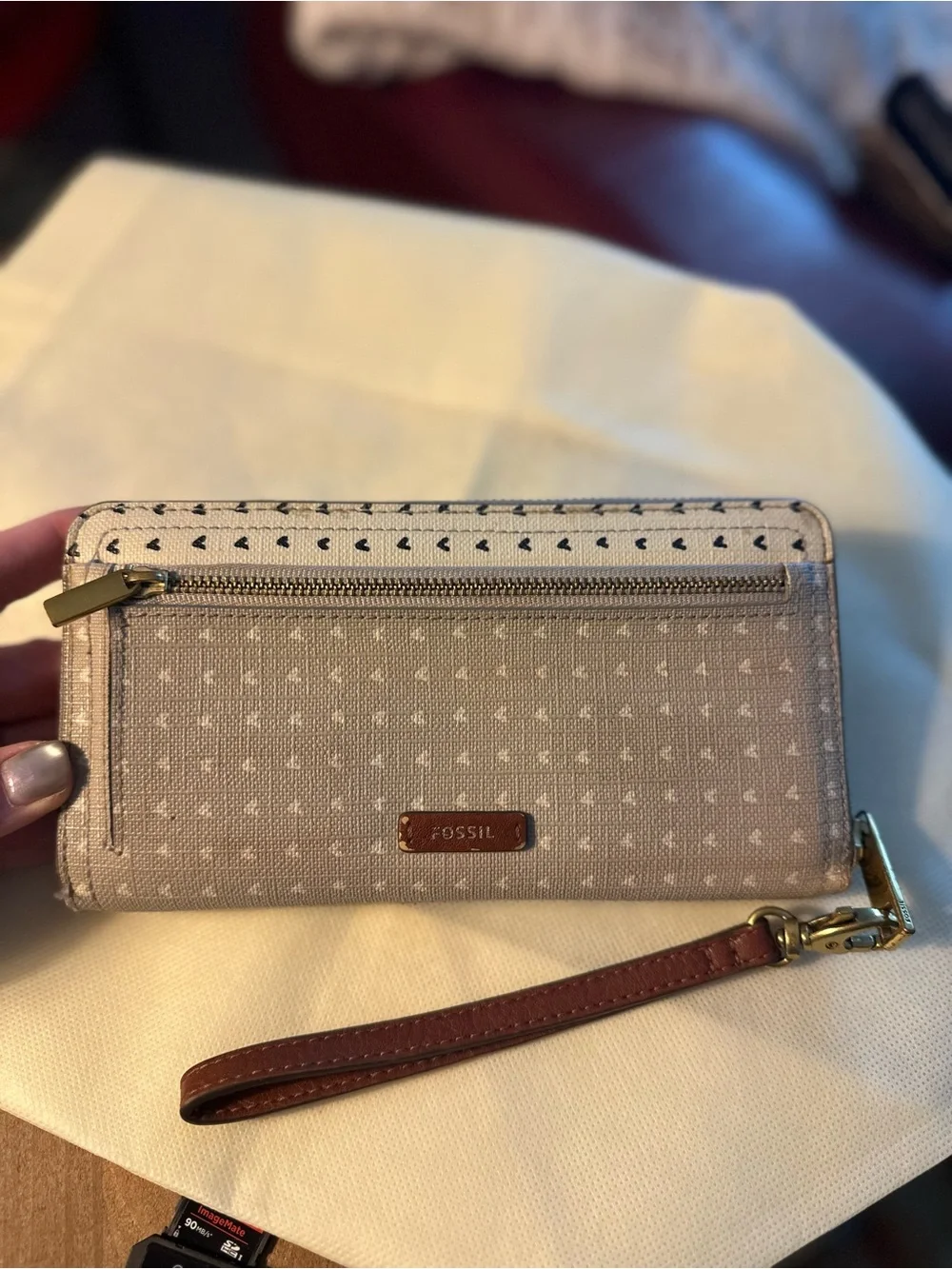 Fossil Putty and white exterior with black hearts; with brown lining Wristlet